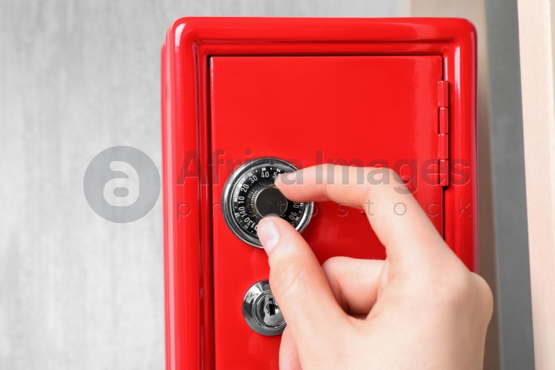 Man opening steel safe with mechanical combination lock, closeup