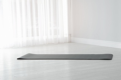Rubber yoga mat on floor indoors. Space for text