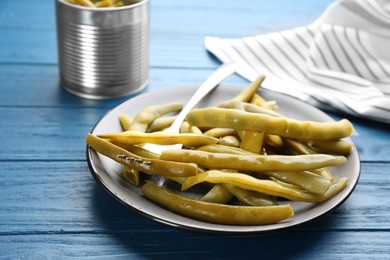 Canned green beans on blue wooden table, closeup
