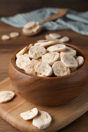 Bowl with dried banana slices on wooden table, closeup