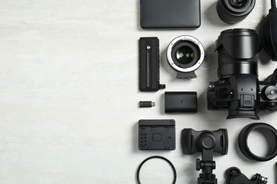 Camera and video production equipment on light background, flat lay. Space for text