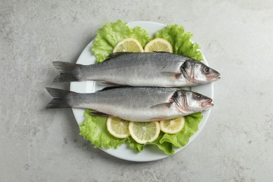 Photo of Tasty sea bass fish on grey textured table, top view