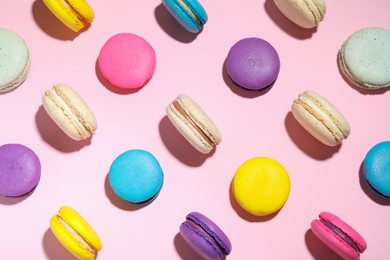 Delicious colorful macarons on pink background, flat lay