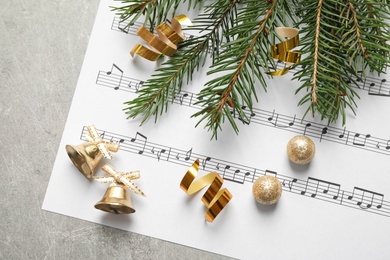 Christmas decorations and music sheet on grey stone table, flat lay