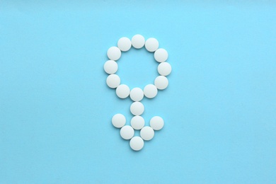 Male sign made of white pills on light blue background, flat lay. Potency problems
