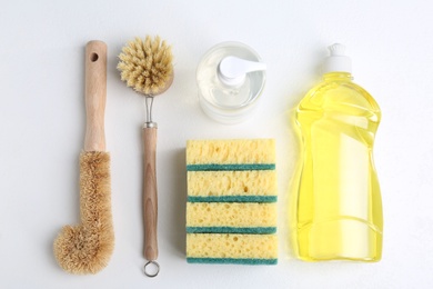 Flat lay composition with cleaning supplies for dish washing on white background