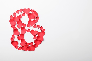 Photo of Number 8 made with red paper hearts on white background, top view. International Women's day