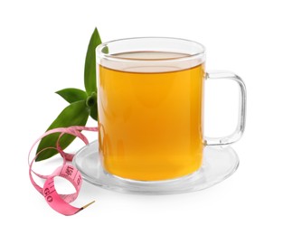 Glass cup of diet herbal tea, measuring tape \and fresh leaves on white background. Weight loss