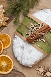Decorated traditional Christmas Stollen on wooden table, flat lay