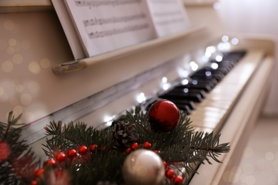 Fir branches with festive decor on piano keys indoors, space for text. Christmas music