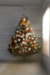 Blurred view of beautifully decorated Christmas tree indoors. Bokeh effect
