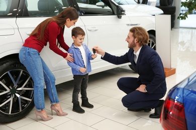 Car salesman working with family in dealership