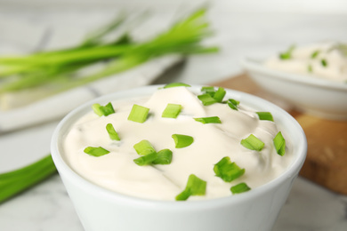 Fresh sour cream with onion in bowl, closeup