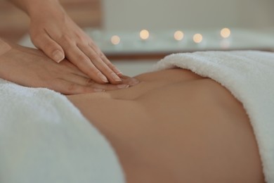 Photo of Woman receiving professional belly massage in wellness center, closeup