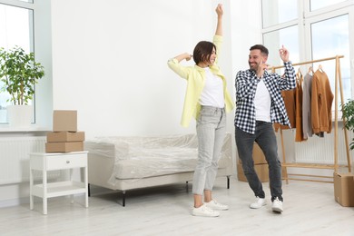 Photo of Happy couple dancing in new apartment. Moving day