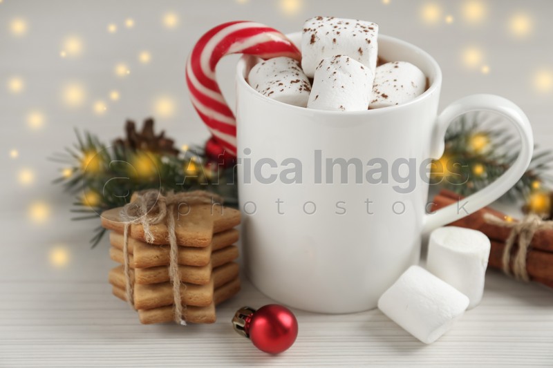 Composition with delicious marshmallow cocoa and Christmas decor on white wooden table