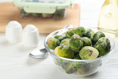 Frozen Brussels sprouts on white wooden table. Vegetable preservation
