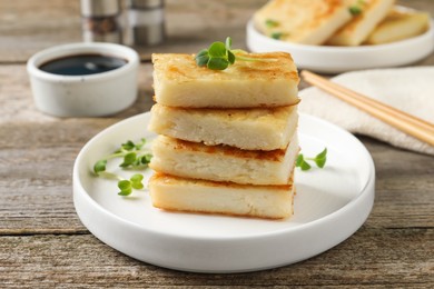 Delicious turnip cake with microgreens served on wooden table
