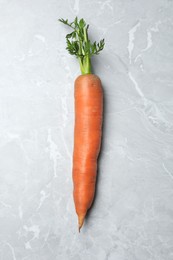 Fresh ripe juicy carrot on light grey marble table, top view