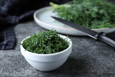 Bowl of fresh dill on grey table, space for text