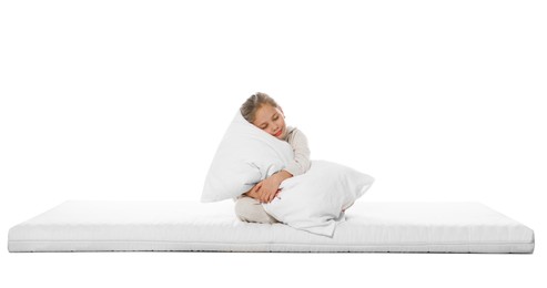 Sleepy girl hugging pillow on mattress against white background