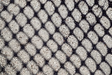 Pattern made with shadow of fence on asphalt