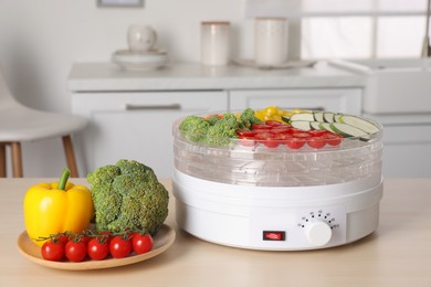 Vegetables and fruit dehydrator machine on wooden table in kitchen