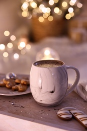 Cup of tasty hot drink and cookies on wooden table. Christmas atmosphere