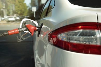 Photo of Refueling modern car with petrol pump on gas station, closeup