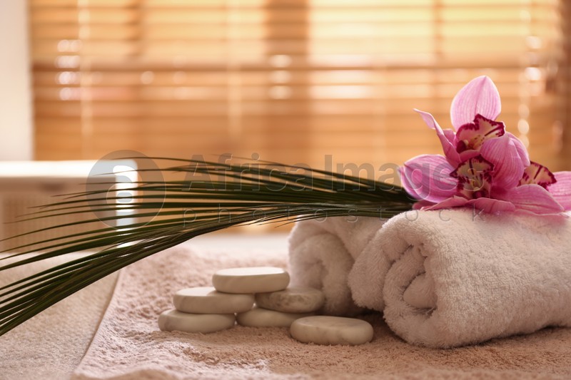 Photo of Beautiful spa accessories on massage table in room