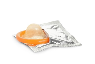 Unpacked orange condom isolated on white. Safe sex