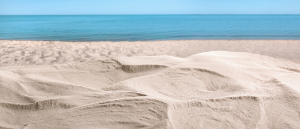 Beautiful beach with white sand near ocean, closeup view. Banner design