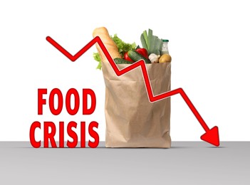 Global food crisis concept. Global food crisis concept. Kraft paper bag with different fruits, vegetables and decline graph on grey table against white background