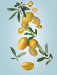 Image of Fresh olives and leaves falling on pale light blue background