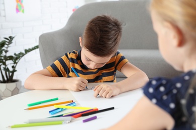 Cute little children drawing together at home
