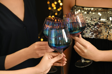 Women clinking glasses of red wine at party, closeup