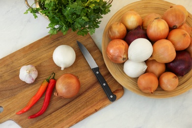 Fresh onions, chili peppers and garlic on table, flat lay