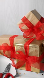 Beautifully wrapped gift boxes on white table, closeup