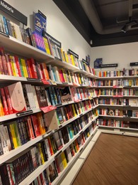 Photo of WARSAW, POLAND - JULY 23, 2022: Rack with different books in store