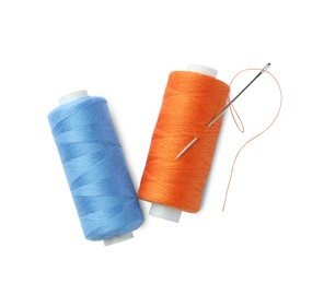 Different colorful sewing threads and needle on white background, top view