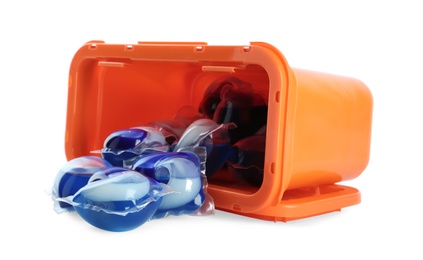 Overturned box with laundry capsules on white background