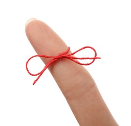 Woman showing index finger with tied red bow as reminder on white background, closeup