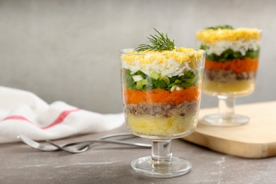 Photo of Traditional russian salad Mimosa served on grey table, space for text