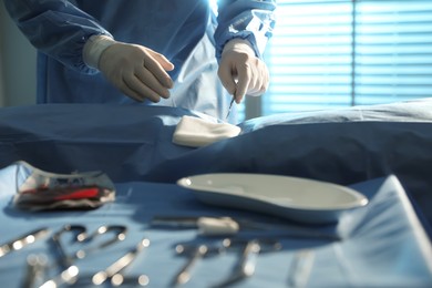 Photo of Professional surgeon with instruments performing operation in clinic, closeup