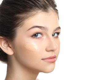 Beautiful girl with foundation smear on her face against white background