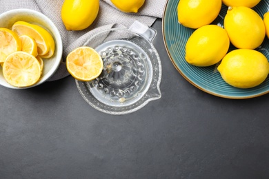 Photo of Flat lay composition with freshly squeezed lemon juice on dark table. Space for text