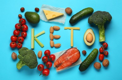 Word Keto made with products surrounded by different food for low carb diet on light blue background, flat lay