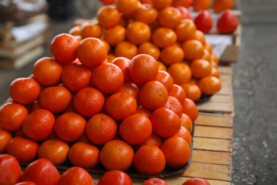 Photo of Fresh ripe tangerines fruit on counter at wholesale market