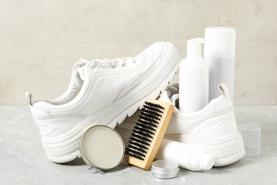 Composition with stylish footwear and shoe care accessories on light grey table