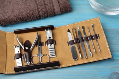 Photo of Manicure set in case on light blue wooden background